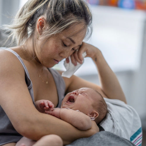 mum holding her crying baby - Mustela Australia - 1