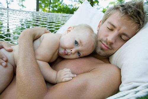 dad-lying-down-with-baby-on-top-of-him - Mustela Australia - 1