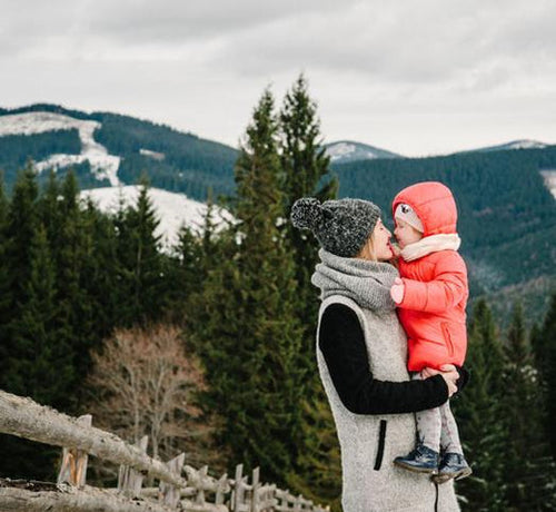 mum-holding-child-in-mountains-with-snow - Mustela Australia - 1