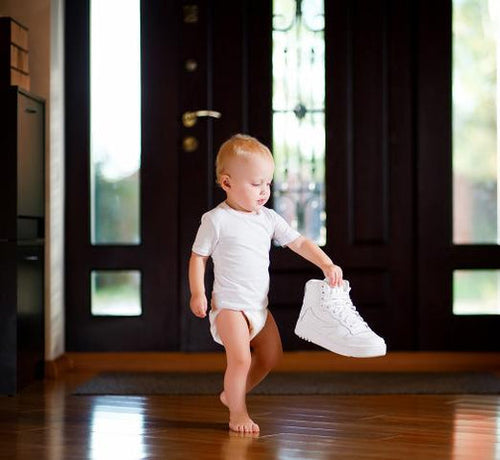 toddler-walking-with-big-shoe-in-hand - Mustela Australia - 1
